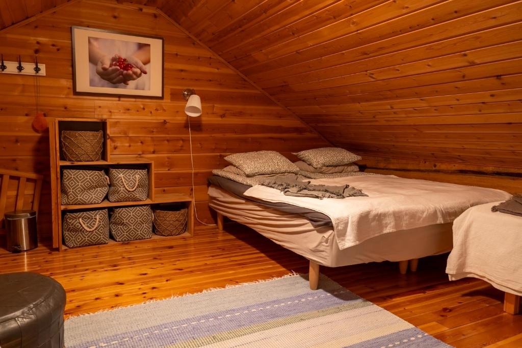 ロヴァニエミにあるKotatuli Forest Lodgeの木造キャビン内のベッド1台が備わるベッドルーム1室を利用します。