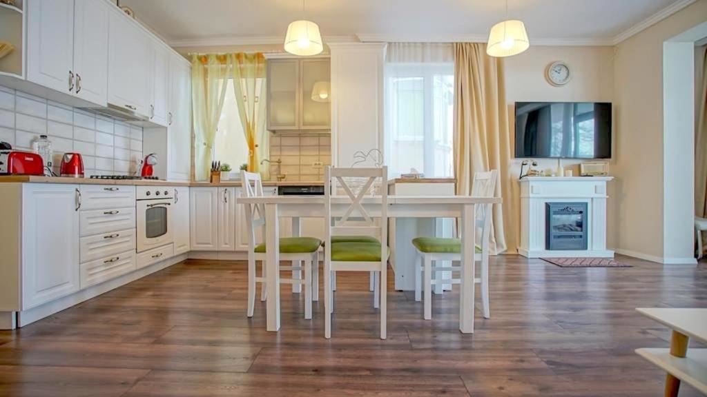 ブラショヴにあるCentral Maximus Apartmentのキッチン(白いテーブル、椅子付)