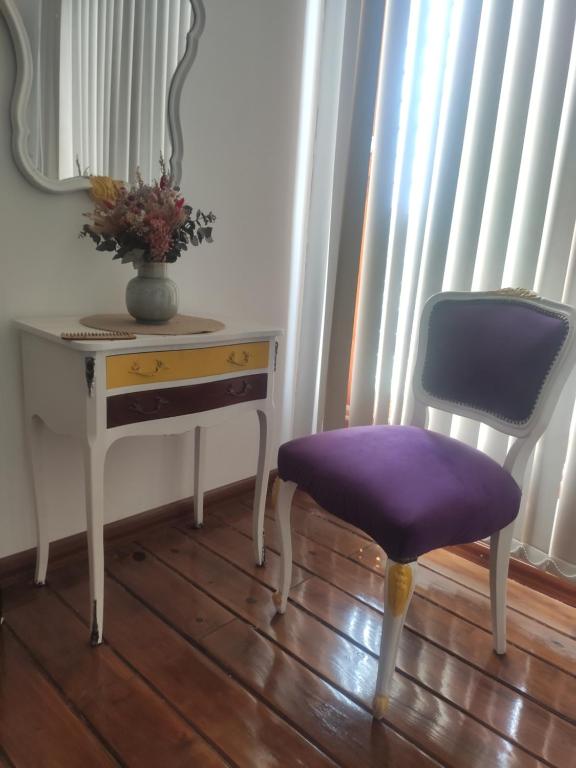 einen Stuhl neben einem Schreibtisch mit einem Spiegel in der Unterkunft El descanso 