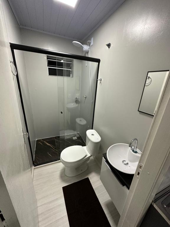 a bathroom with a shower and a toilet and a sink at Loft Lux 2 in Chapecó