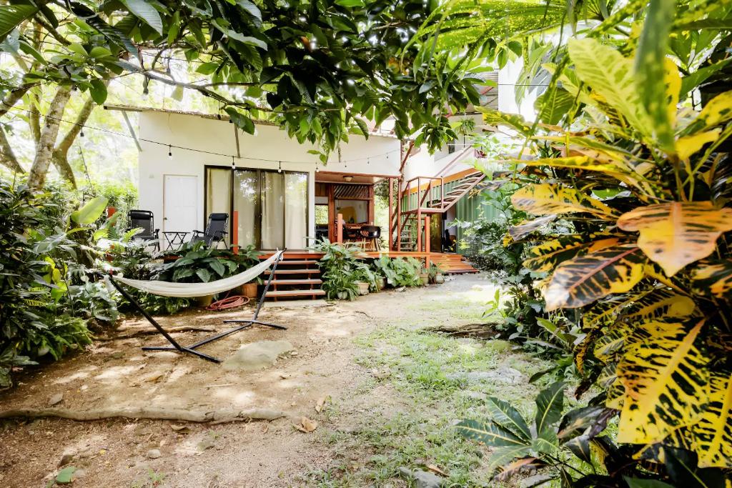 ein Haus mit Hängematte inmitten eines Gartens in der Unterkunft Osa de Rio in Uvita