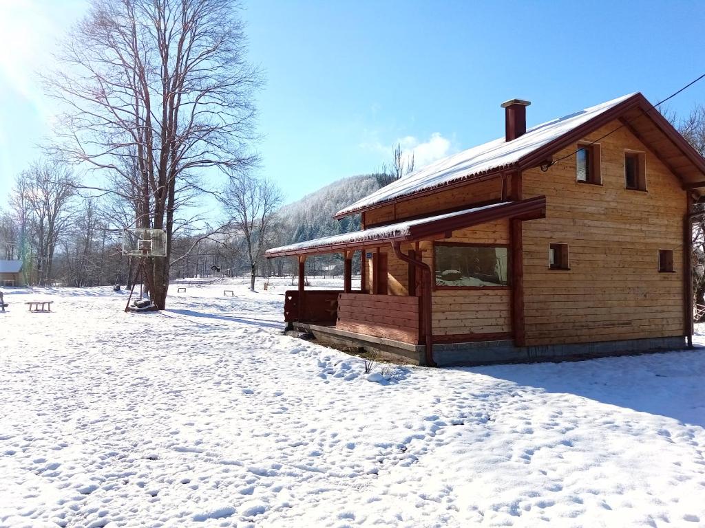 a wooden cabin with snow on the ground at Kuca za odmor Magicna livada in Podgrab