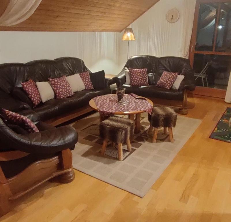 un soggiorno con divani in pelle e tavolo di Apartment ANDA a Bad Kleinkirchheim