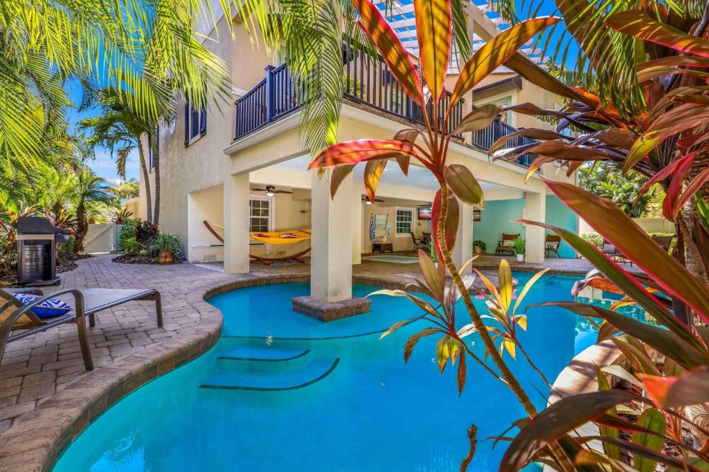 uma piscina no quintal de uma casa com palmeiras em Coconut Cottage em Holmes Beach