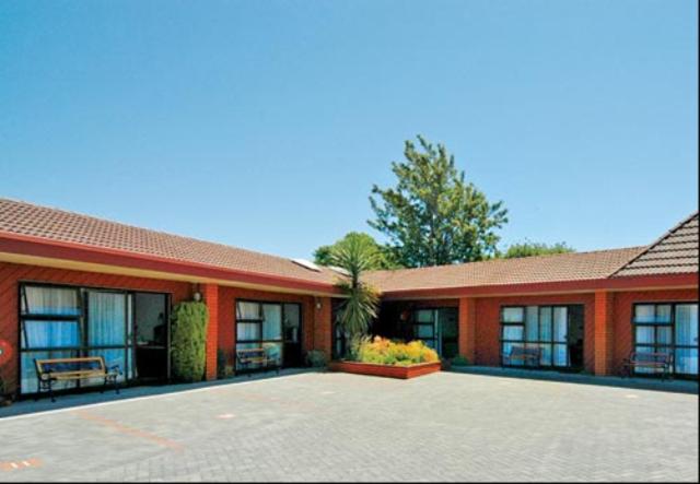 ein rotes Gebäude mit vielen Fenstern in der Unterkunft Ace High Motor Inn in Napier