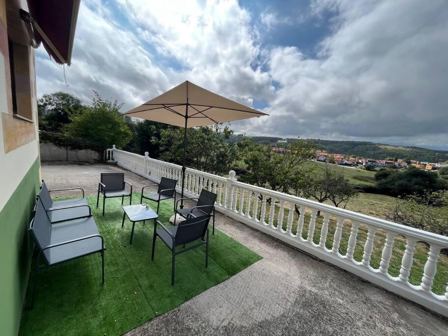 une terrasse avec des chaises et une table avec un parasol dans l'établissement Casa Musoles, à Comillas