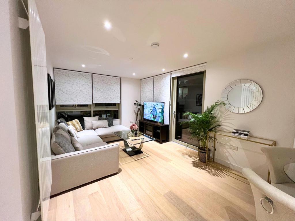 a living room with a white couch and a tv at Stylish Apartment Docklands in London