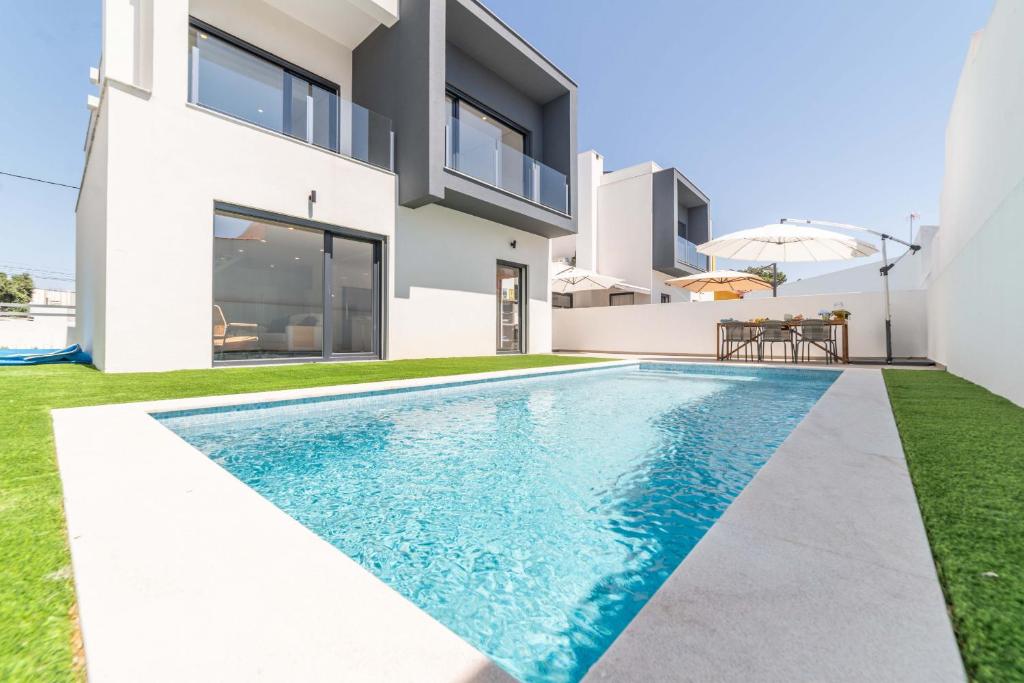 - une piscine dans l'arrière-cour d'une maison dans l'établissement Villa Beija Flor, à Charneca