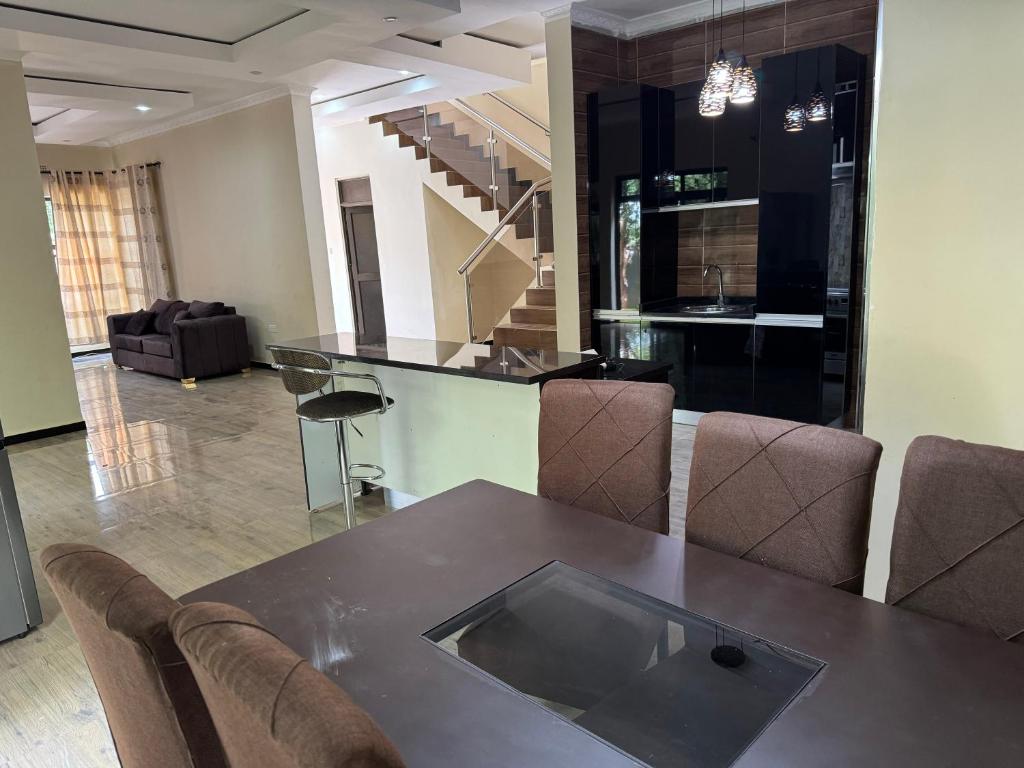 uma sala de jantar com mesa e cadeiras em Steady State Apartment 1 em Lusaka