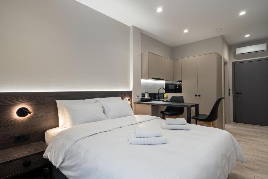 ein Schlafzimmer mit einem großen weißen Bett mit Handtüchern darauf in der Unterkunft d Suites and Apartments in Ioannina