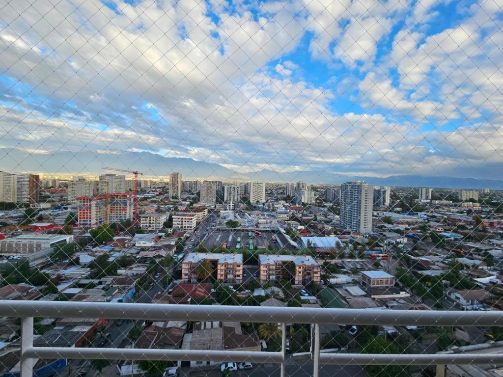 een uitzicht op de stad via een hek met een ketting bij Depa La Cisterna in Santiago