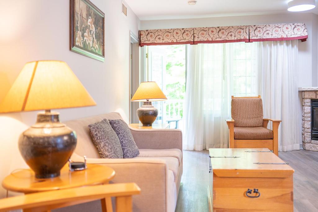 een woonkamer met een bank en een tafel met een lamp bij Horseshoe Valley Suites - The Verdant in Shanty Bay