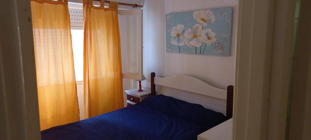 una camera con un letto blu e una finestra di Tritones Playa a Pinamar
