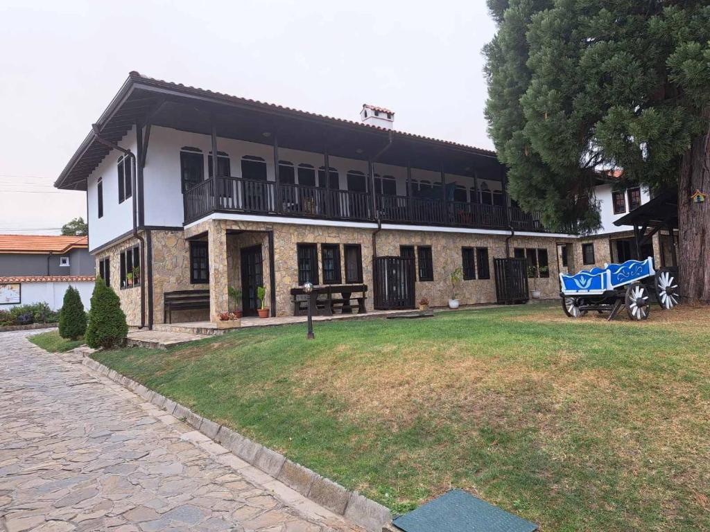 a house with a blue cart in front of it at Кедър 5 in Dolna Banya