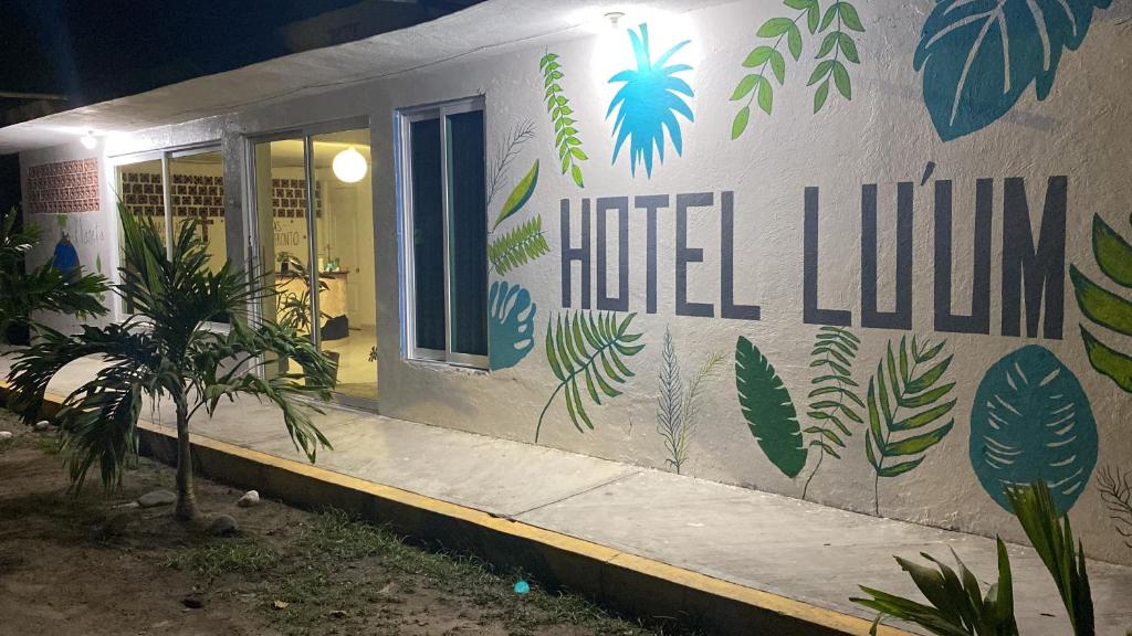 un bâtiment avec un mur orné de plantes peintes sur lui dans l'établissement Hotel Lu'um, à Tecolutla