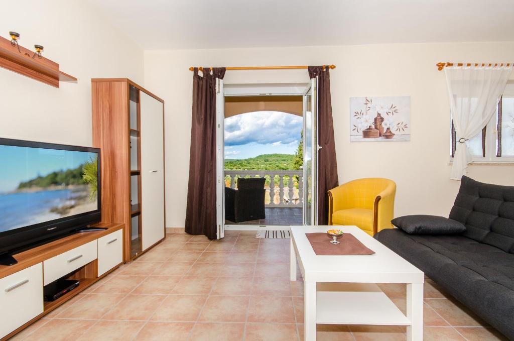 salon z kanapą i telewizorem w obiekcie Apartments Villa Amfora w Rovinj