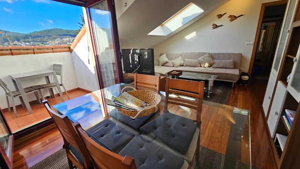 ein Esszimmer und ein Wohnzimmer mit einem Glastisch in der Unterkunft Apart 52 m2 en Sabaris-Baiona in Baiona