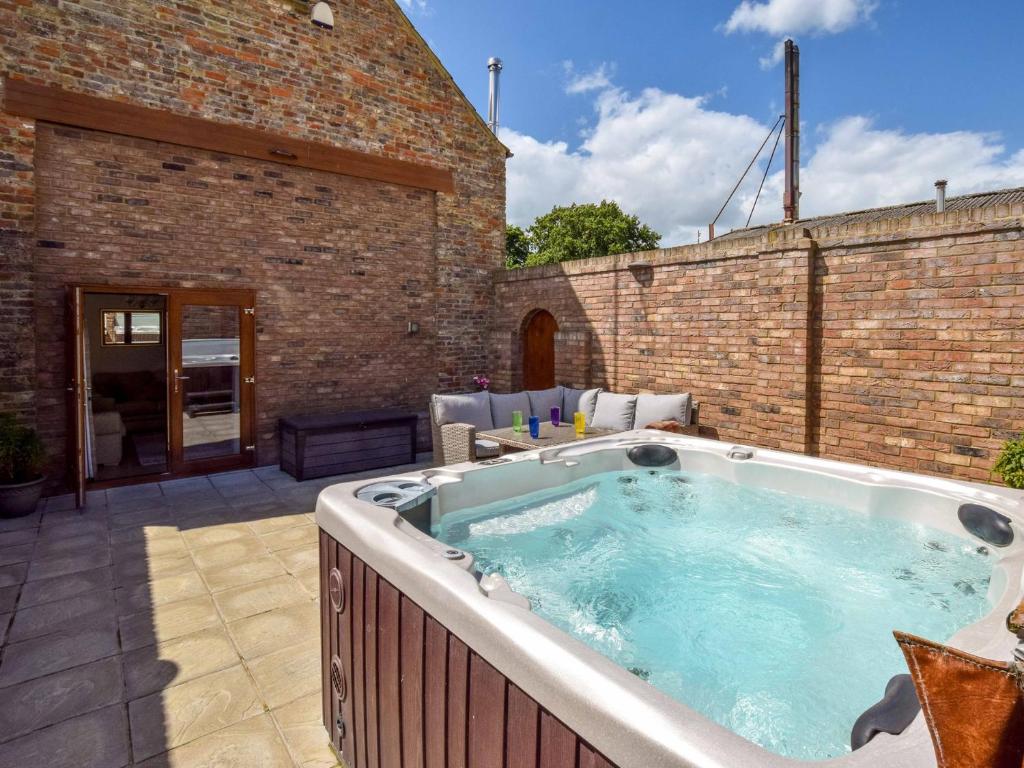 a hot tub on the patio of a building at 2 Bed in Filey 79280 in Wold Newton