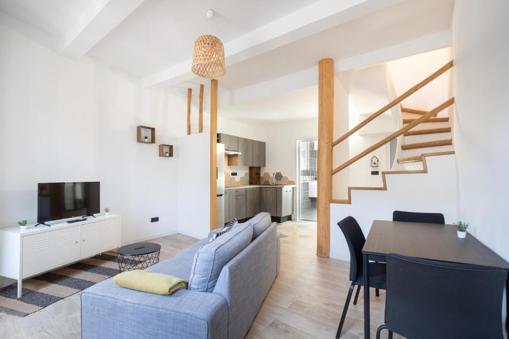 ein Wohnzimmer und ein Esszimmer mit einem blauen Sofa und einem Tisch in der Unterkunft Le Duplex - Hypercentre - Wifi in Carpentras