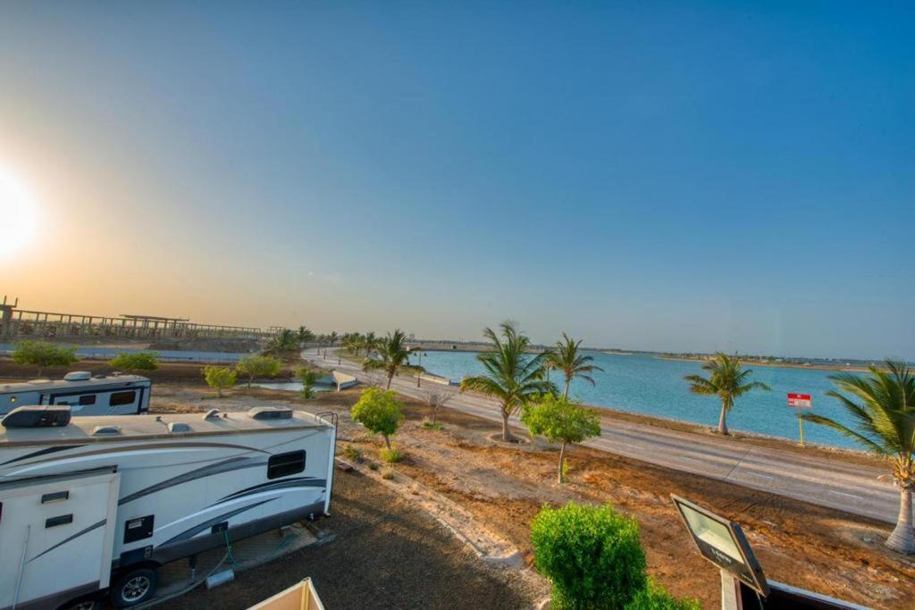 una caravana y una caravana estacionadas junto a una playa en منتجع شاطئ الورد, en Yanbu