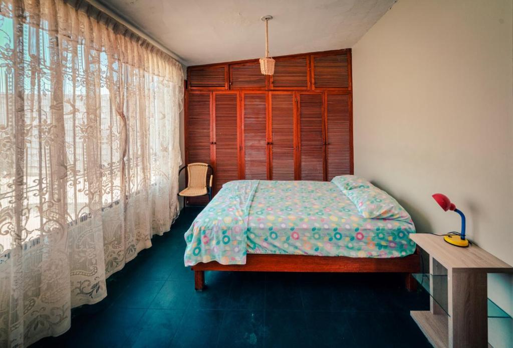 1 dormitorio con cama y ventana en Villa CERRILLOS, en Camaná