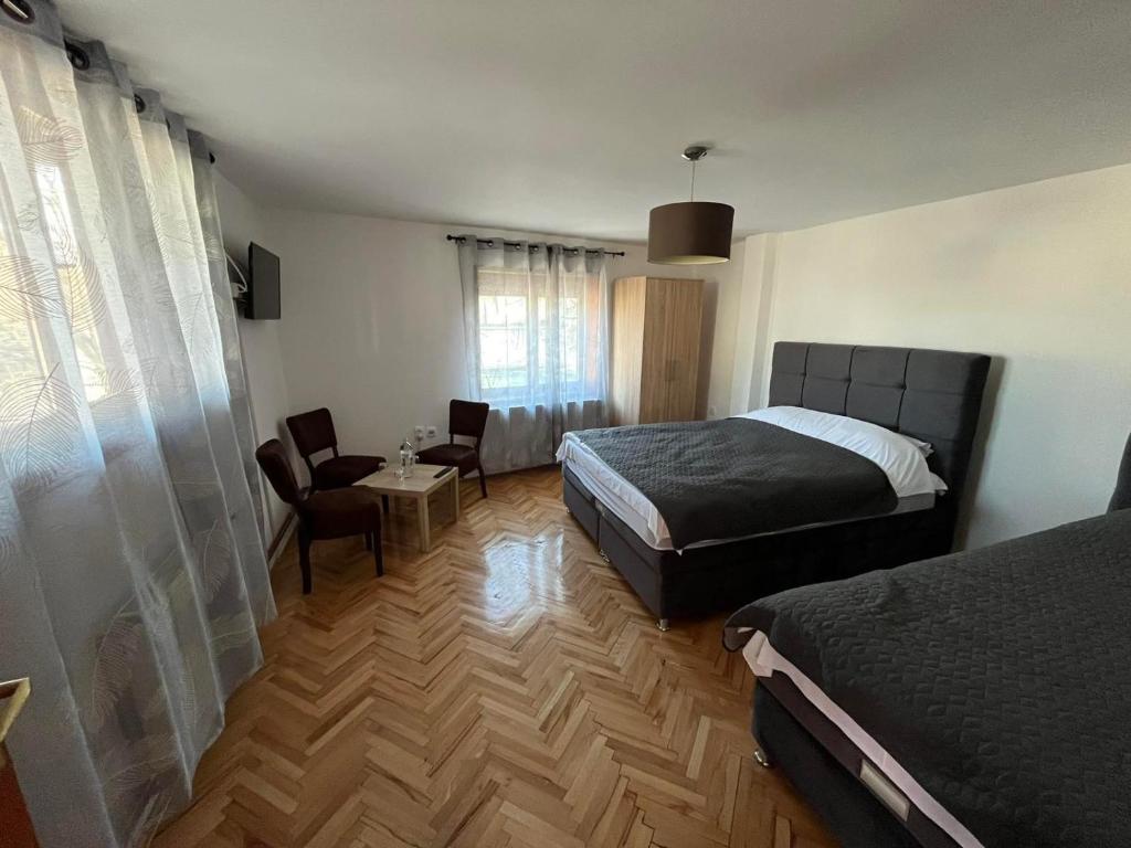 een slaapkamer met een bed en een tafel en stoelen bij 9 mezeta in Pirot