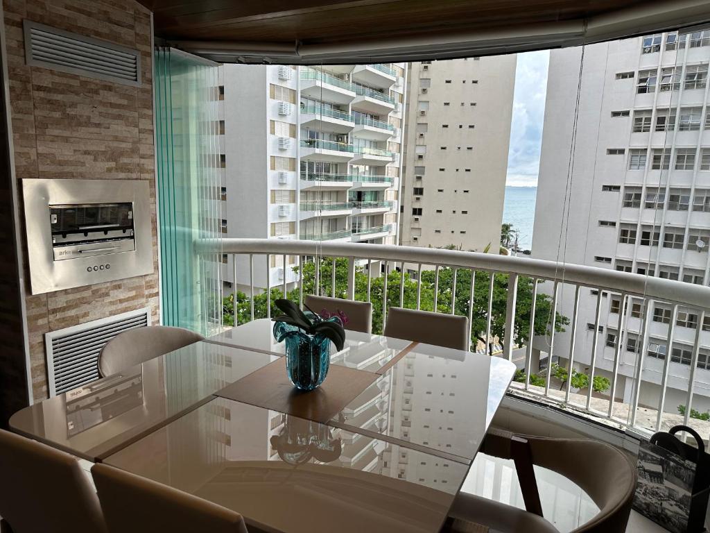 a dining room with a table and chairs on a balcony at Flat botique Guarujá in Guarujá