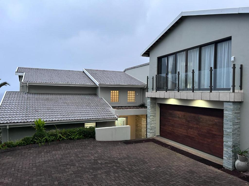 a house with a brick driveway in front of it at Waves of Mercy in Trafalgar