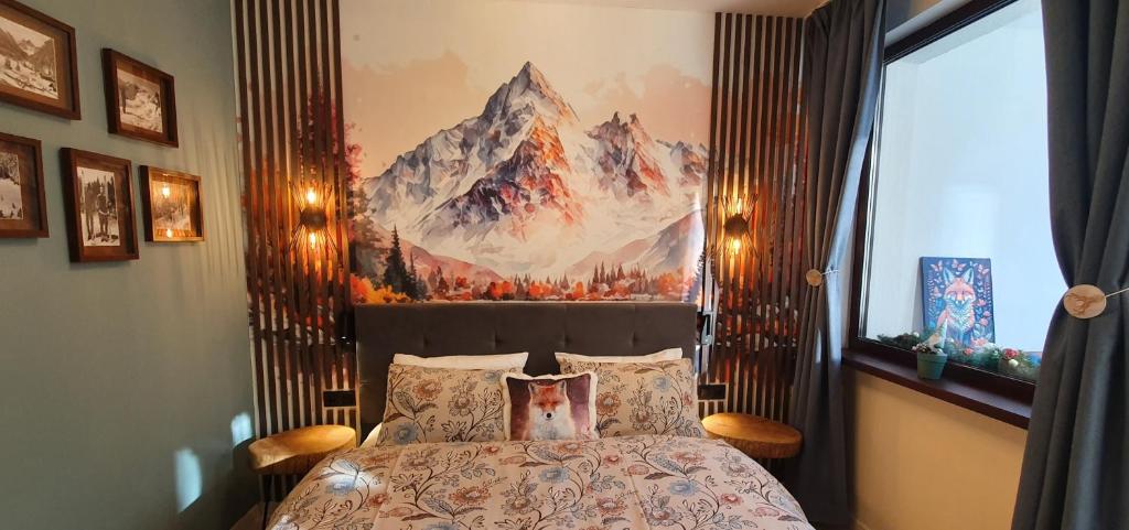 FOX boutique apartment Borovets Gardens في بوروفتس: غرفة نوم بسرير مع لوحة على الحائط