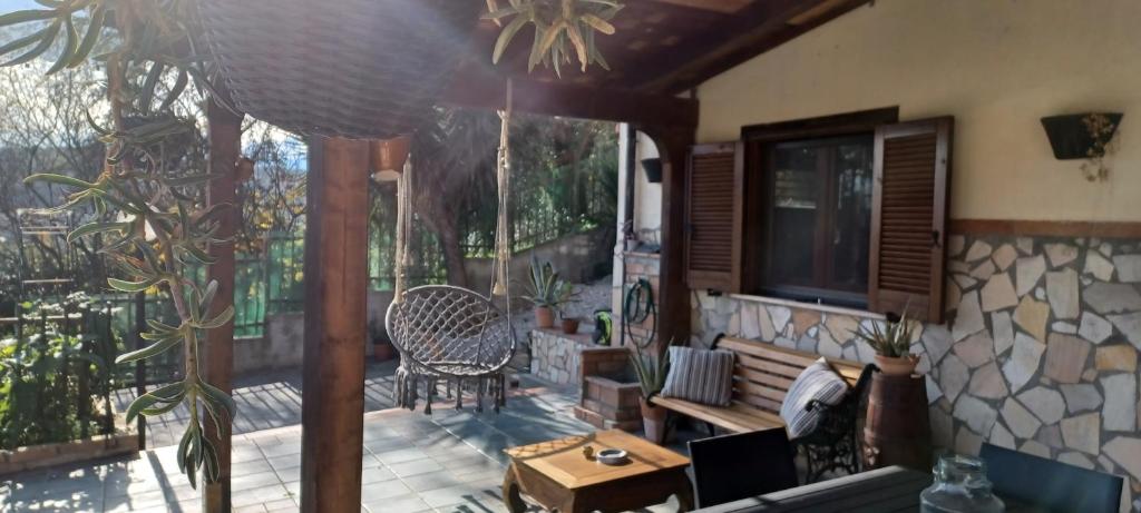 una veranda riparata con una sedia e un tavolo di La Tana di Otto a Montalto Uffugo