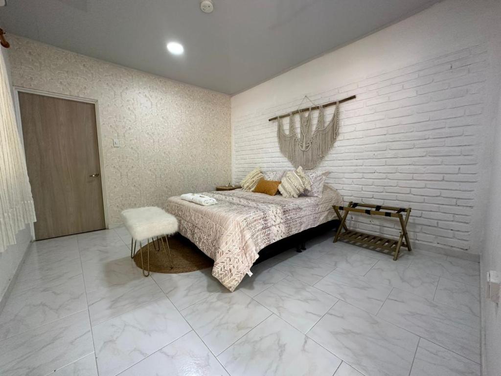 a bedroom with a bed and a brick wall at Deluxe Pacandé, cerca al desierto de la tatacoa in Aipe