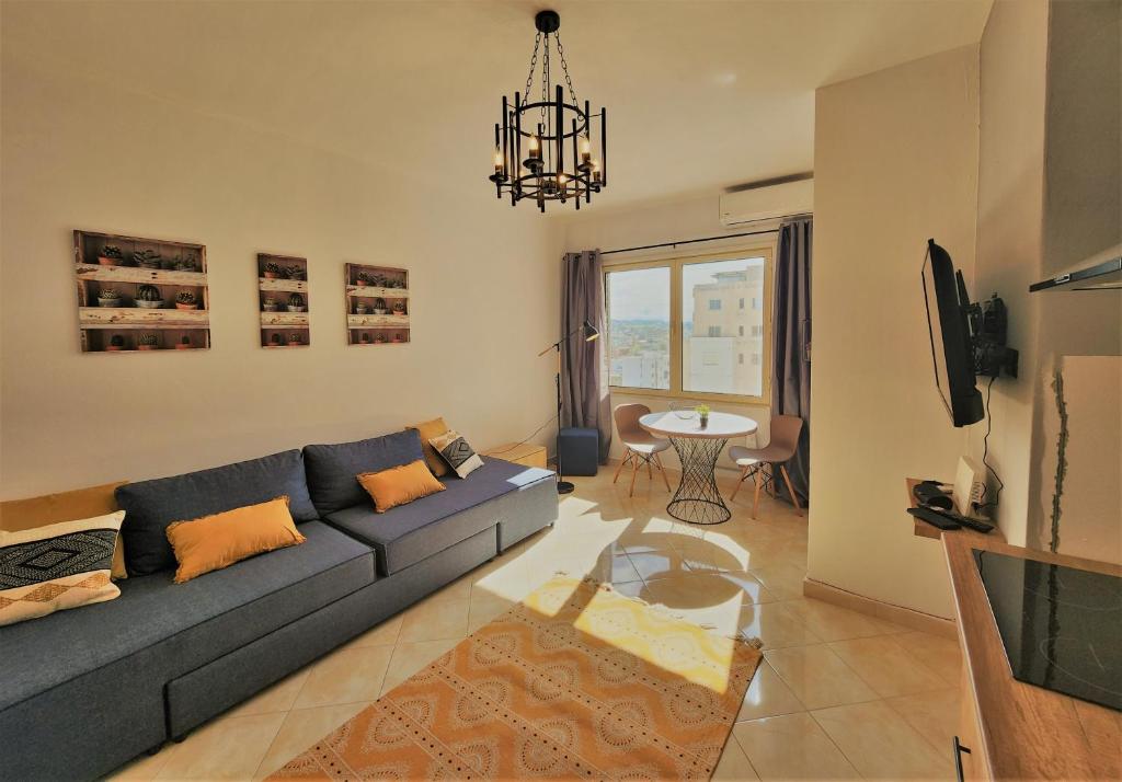 a living room with a blue couch and a table at Dream in Durrës