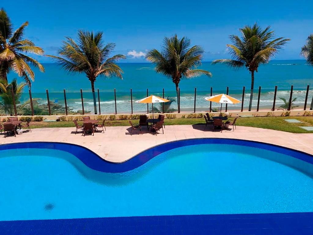 una piscina con vista sulla spiaggia di Flat Frente Mar - Praia de Tabatinga a Conde