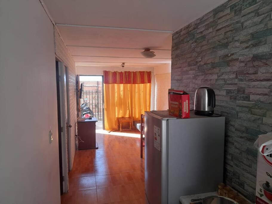 a kitchen with a refrigerator and a brick wall at arriendo casa para 6 personas in Caldera