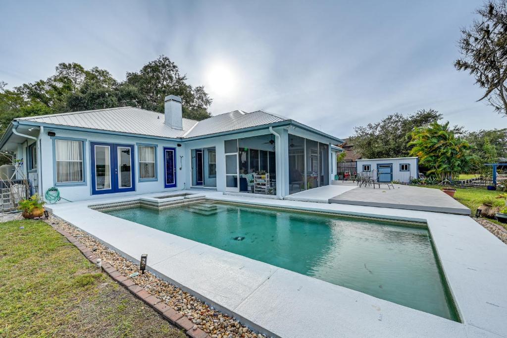 a house with a swimming pool in front of it at Odessa Lake House with Private Pool and Screened Lanai in Odessa