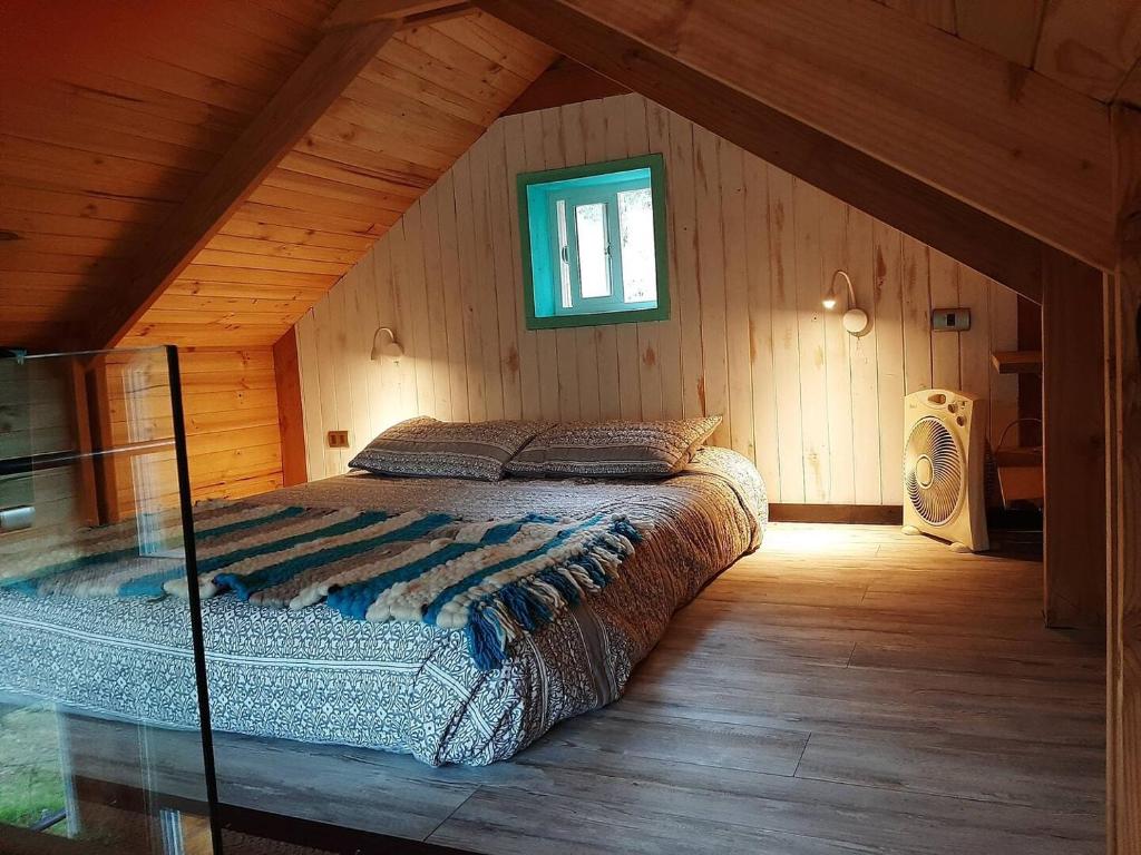 ein Schlafzimmer mit einem großen Bett im Dachgeschoss in der Unterkunft Tiny House Conguillio in Melipeuco