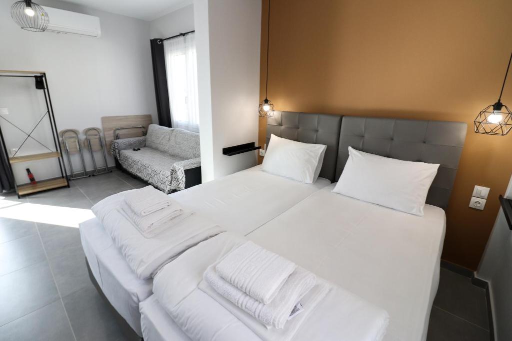 a bedroom with a large white bed with white sheets at LA CASA DE PROFESOR 5 in Kalabaka