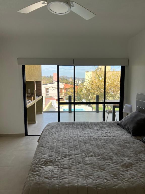 a bedroom with a large bed with a large window at Casaabril in Villa Carlos Paz