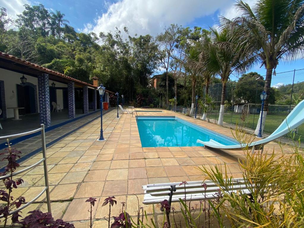uma piscina com escorrega junto a uma casa em Vale Zirá em Vassouras