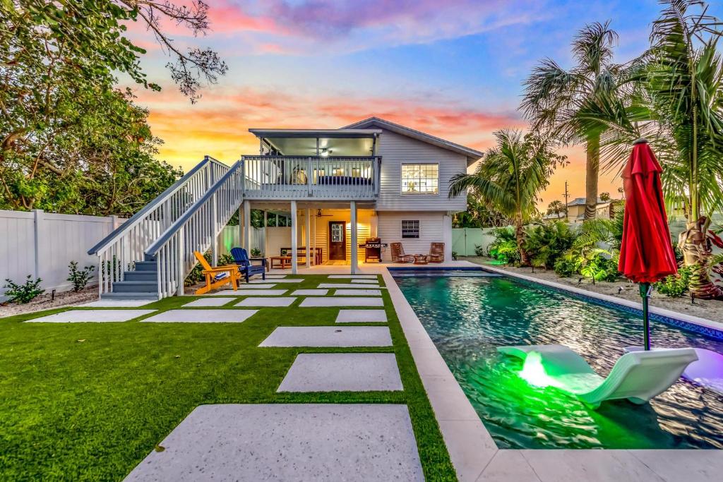 a home with a swimming pool and a house at Surf Side in Anna Maria
