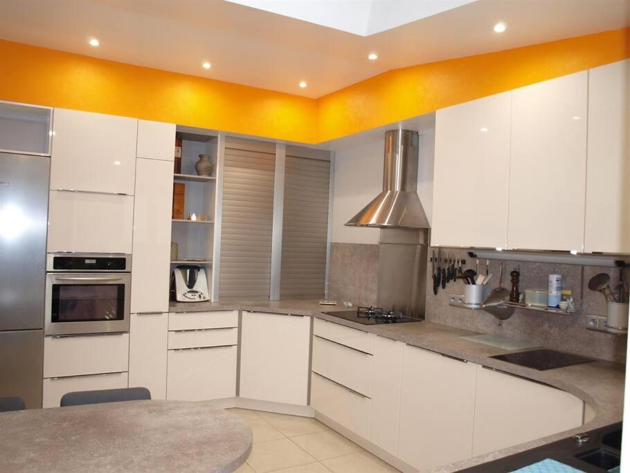 uma cozinha com armários brancos e um forno com placa de fogão em Charming City Home Near Downtown with Garage em Amiens