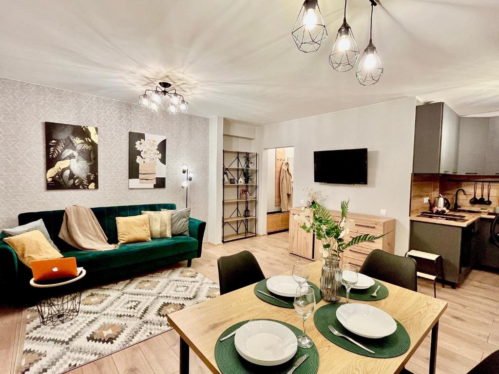 a living room with a green couch and a table at New Stylish Apartment City Center in Narva