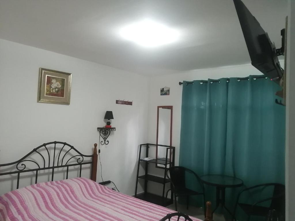 a bedroom with a bed and a blue curtain at Cerca del aeropuerto HABITACIÓN INDEPENDIENTE CON BAÑO PRIVADO Área muy tranquila entre chanis y costa del este in Panama City