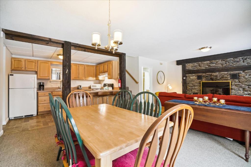 a kitchen and dining room with a wooden table and chairs at Spacious Northbrook 3 townhouse only 2 miles from restaurants & nightlife in Killington