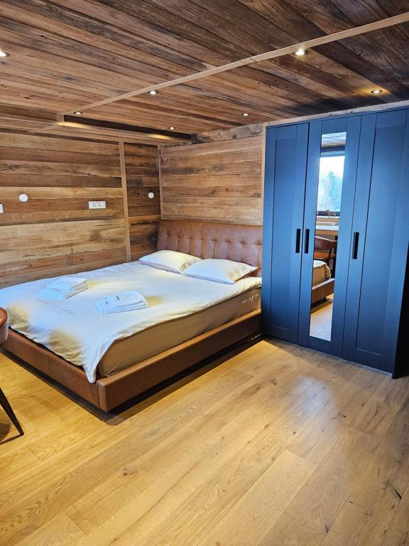 um quarto com uma cama grande e portas de correr azuis em Apartments Bedanc em Kranjska Gora