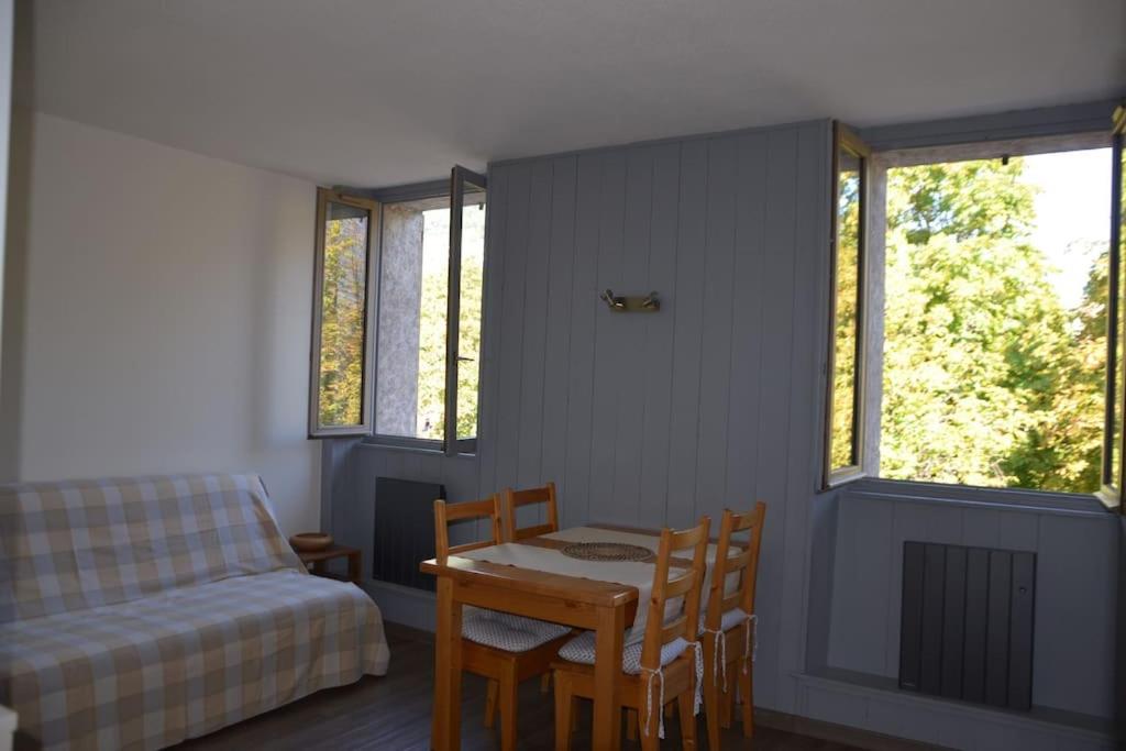 une chambre avec un lit, une table et des chaises dans l'établissement Appartement, au cœur de Sallanches, à Sallanches