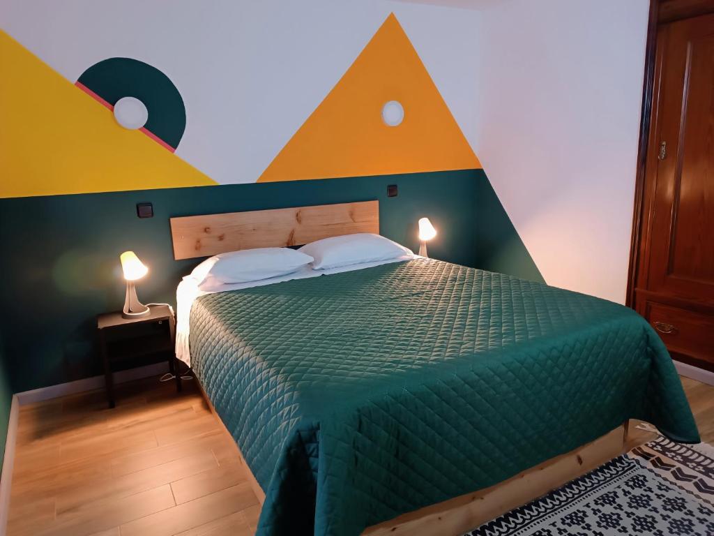 een slaapkamer met een groen bed met een geometrisch hoofdeinde bij Solo Azores - Hospedaria São Jorge in Nordeste