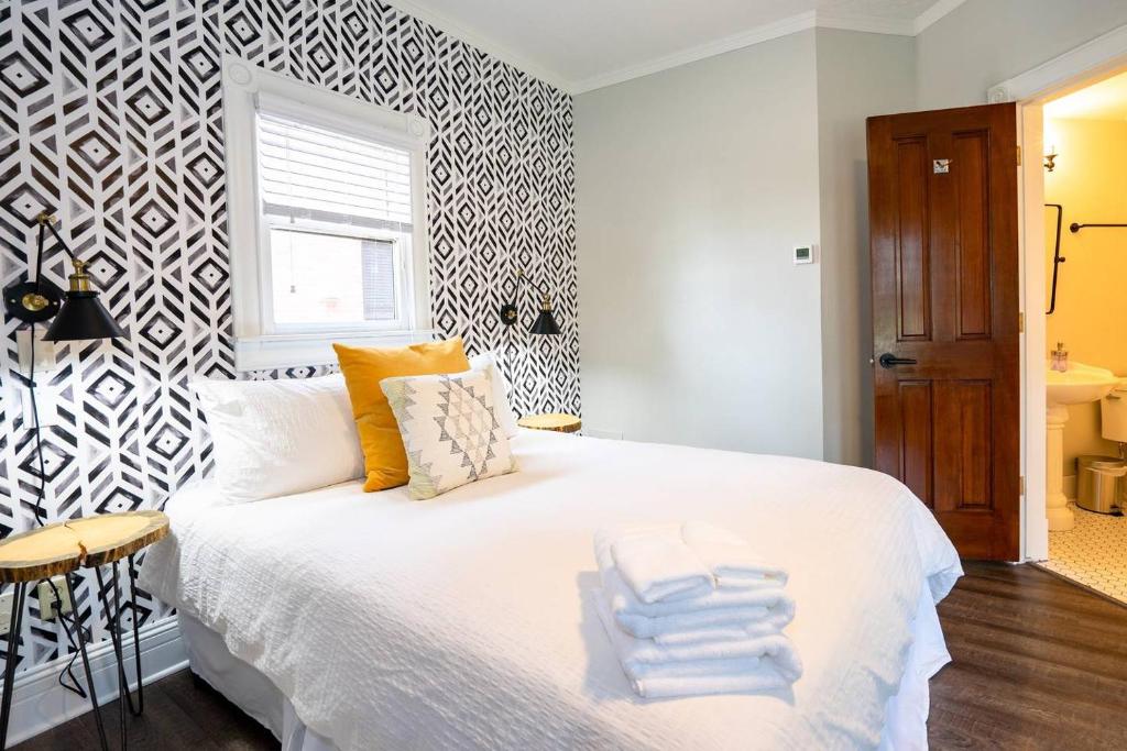 una camera da letto con un letto bianco e asciugamani di The Charming Cowboy a Denver