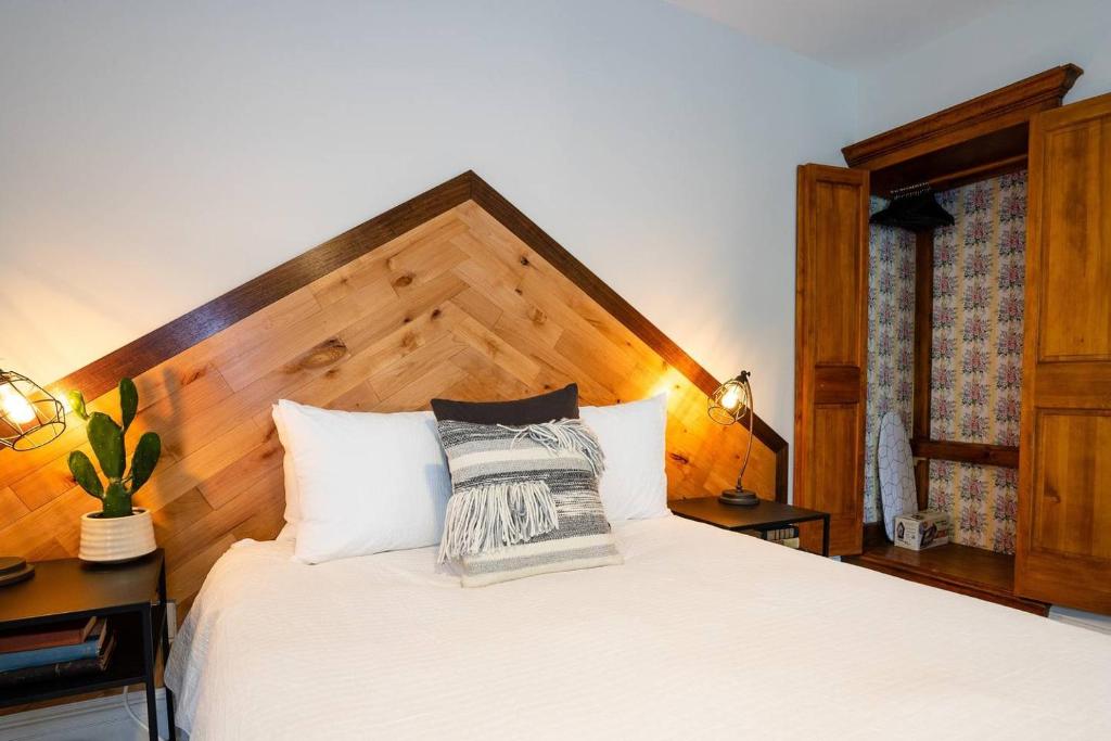 Schlafzimmer mit einem weißen Bett mit einem Kopfteil aus Holz in der Unterkunft The Western Allure in Denver