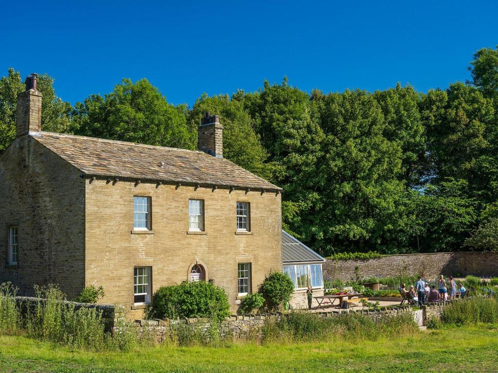 an old brick house with people standing outside of it at The Manse - Uk42249 in Broughton